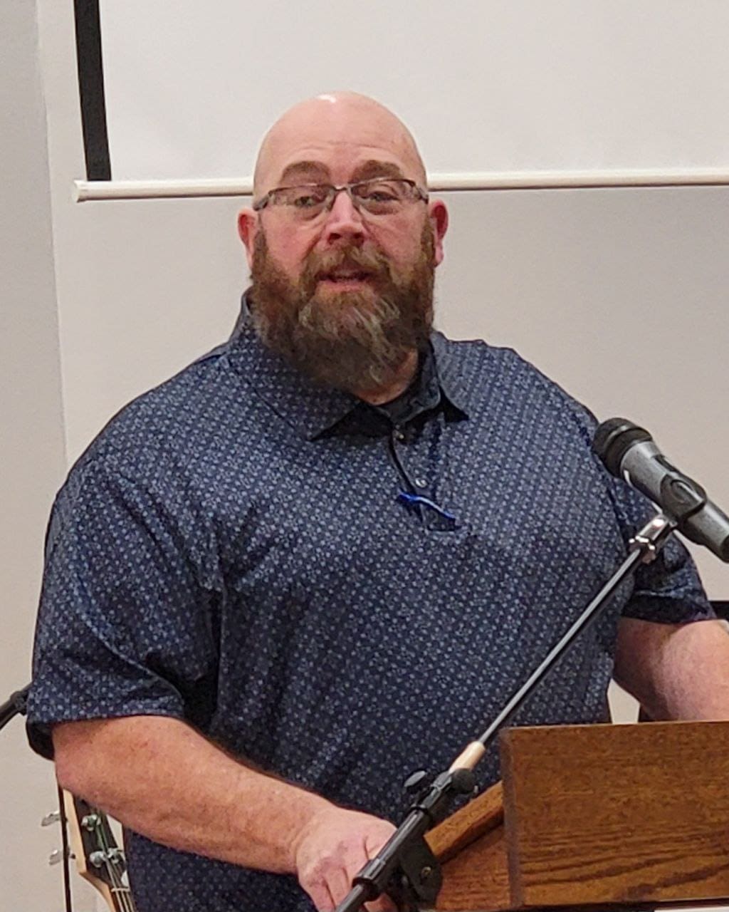 Elder John Birge preaching from the pulpit during Sunday worship at New Covenant Church